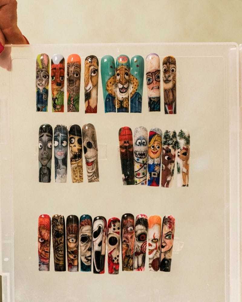 Unique nail art featuring detailed and colorful character designs on artificial nails.