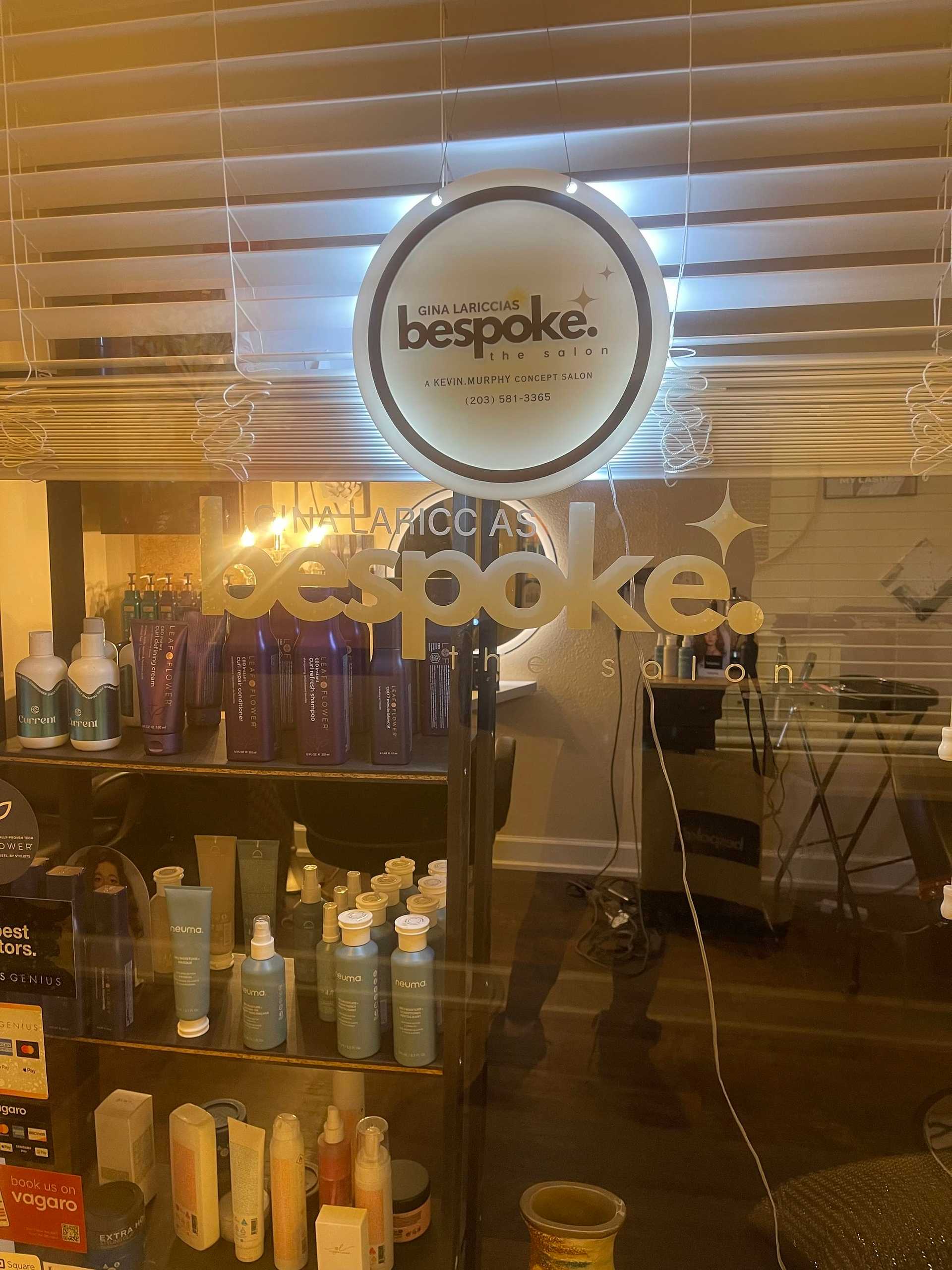 Interior of a hair salon with products on display and a branded sign.