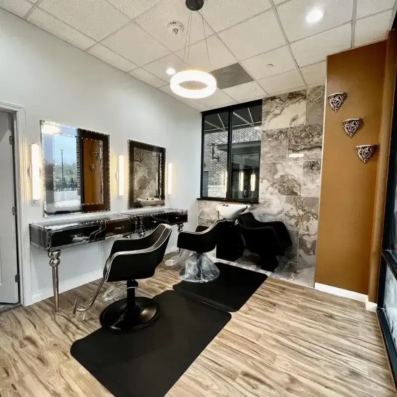 Modern hair salon interior with stylish chairs and mirrors.