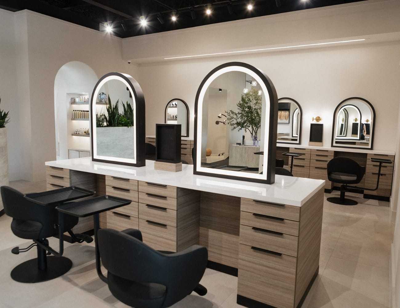 Modern salon interior with stylish workstations and sleek mirrors.