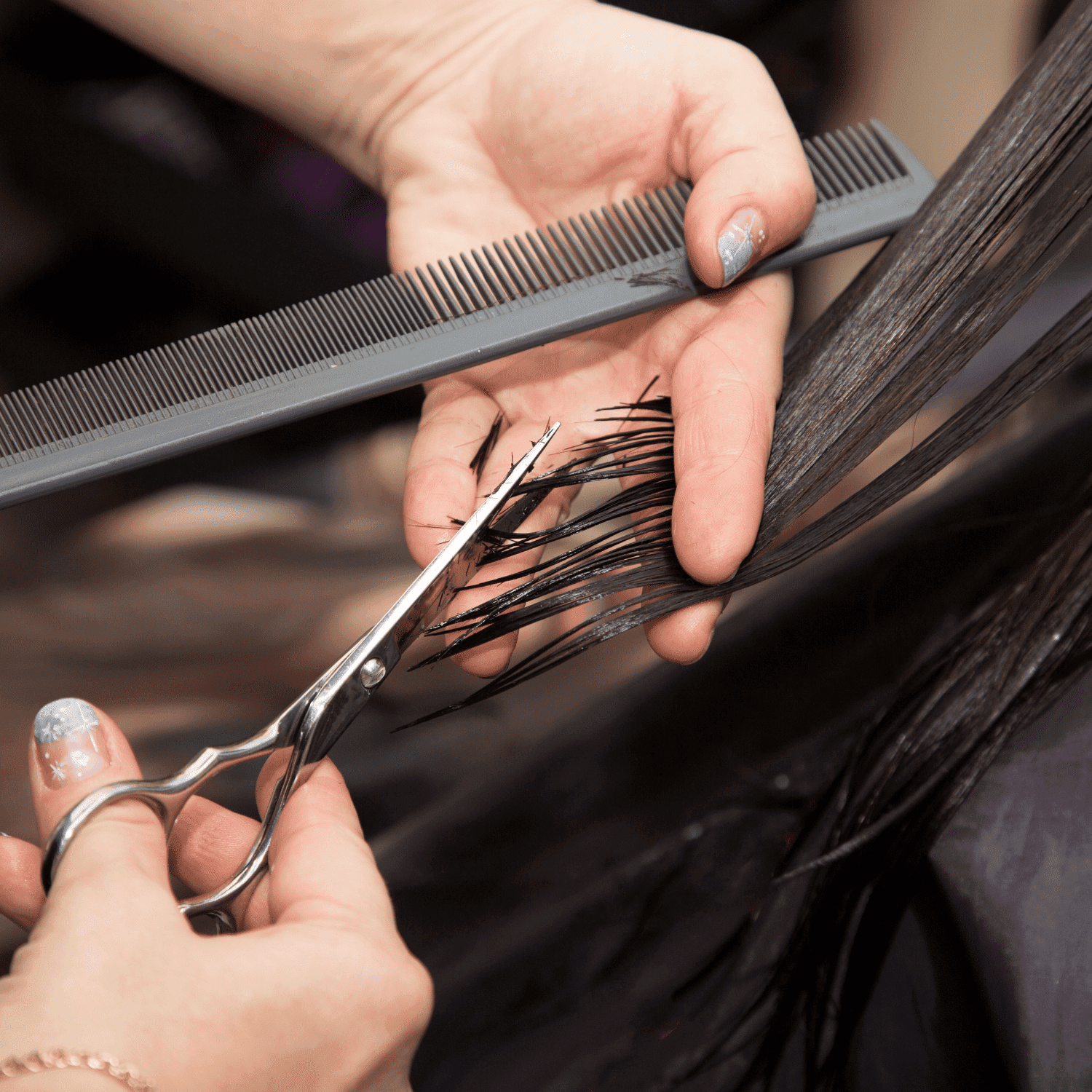 Hair being cut with scissors and comb in a salon, close-up on hands.