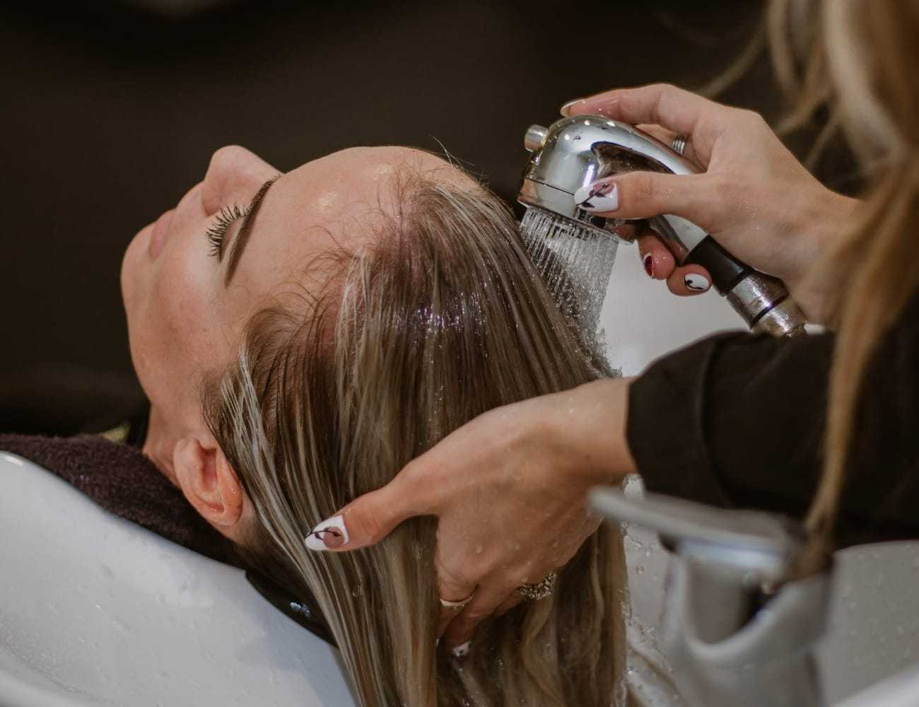 Person getting hair washed at a salon sink.