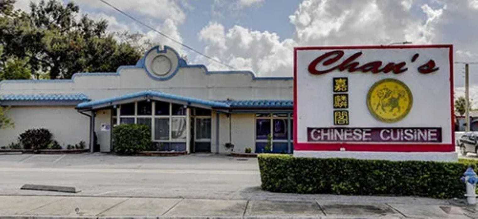 Chinese restaurant with a large sign, “Chan’s Chinese Cuisine,” against a cloudy sky.