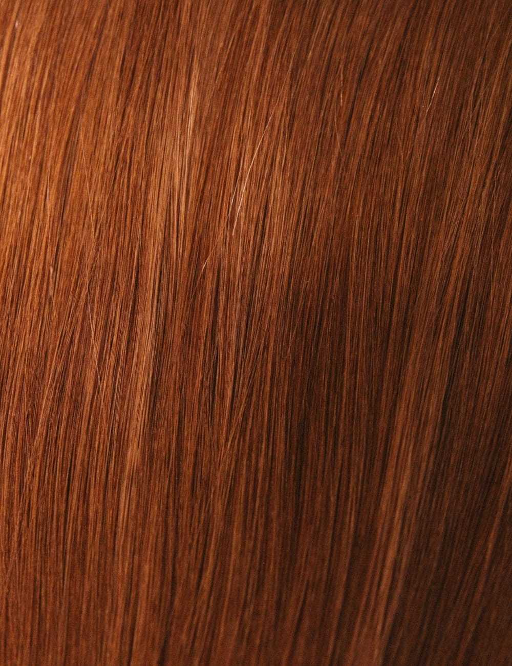 Close-up of long, smooth auburn hair strands.