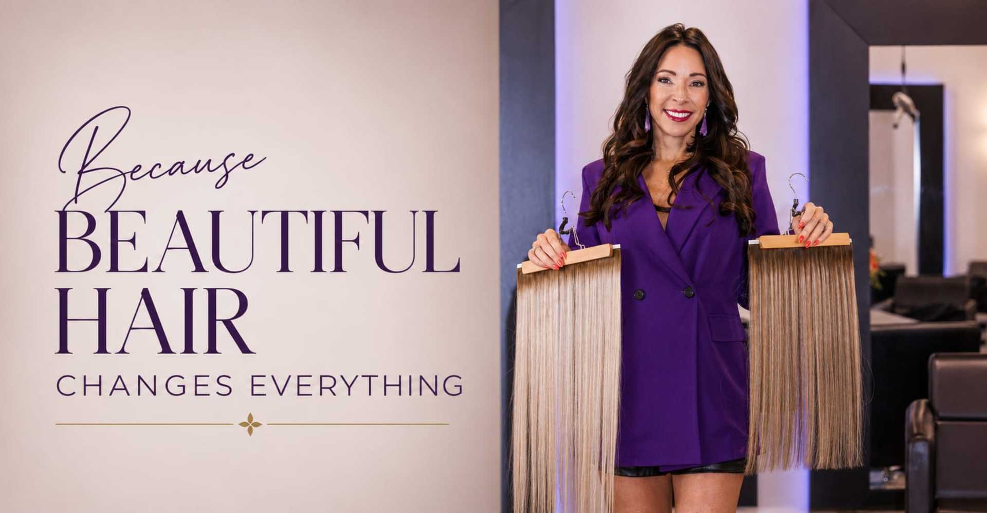 Woman in purple blazer holding hair extensions in a salon.