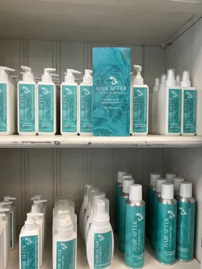 Hair After haircare products arranged on white shelf with blue-green labels.