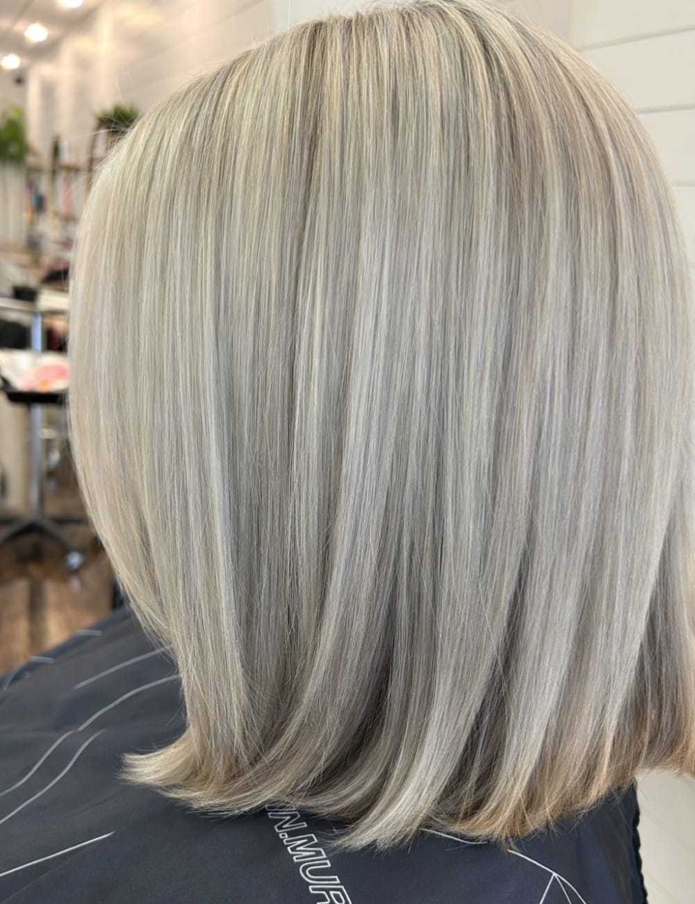 Straight, shoulder-length blonde hair with subtle highlights, styled in a sleek bob cut.