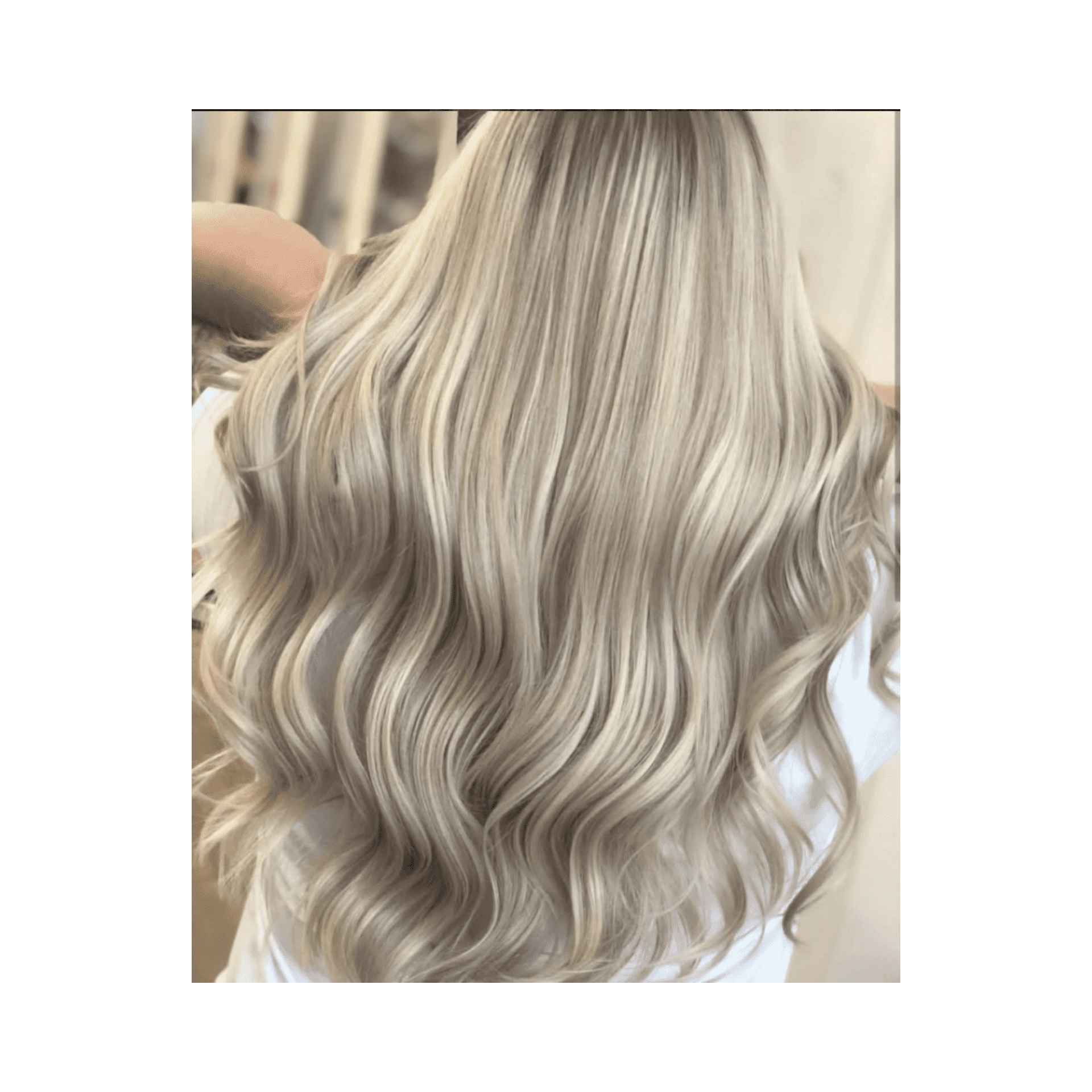 Long, wavy platinum blonde hair cascading over a white shirt.