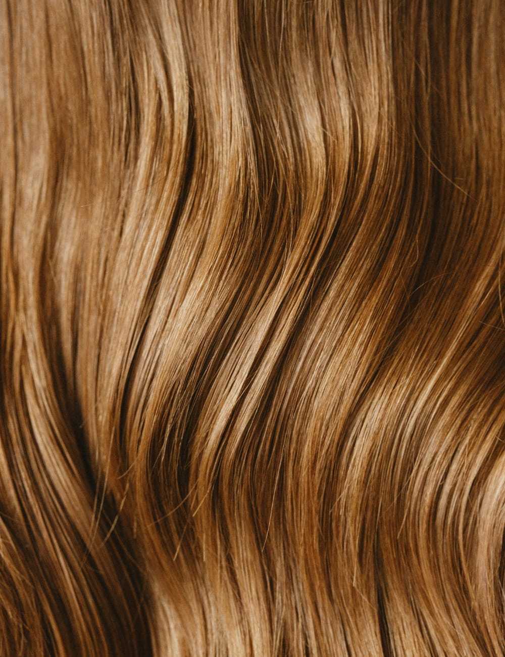 Close-up of shiny, wavy brown hair flowing in soft strands.