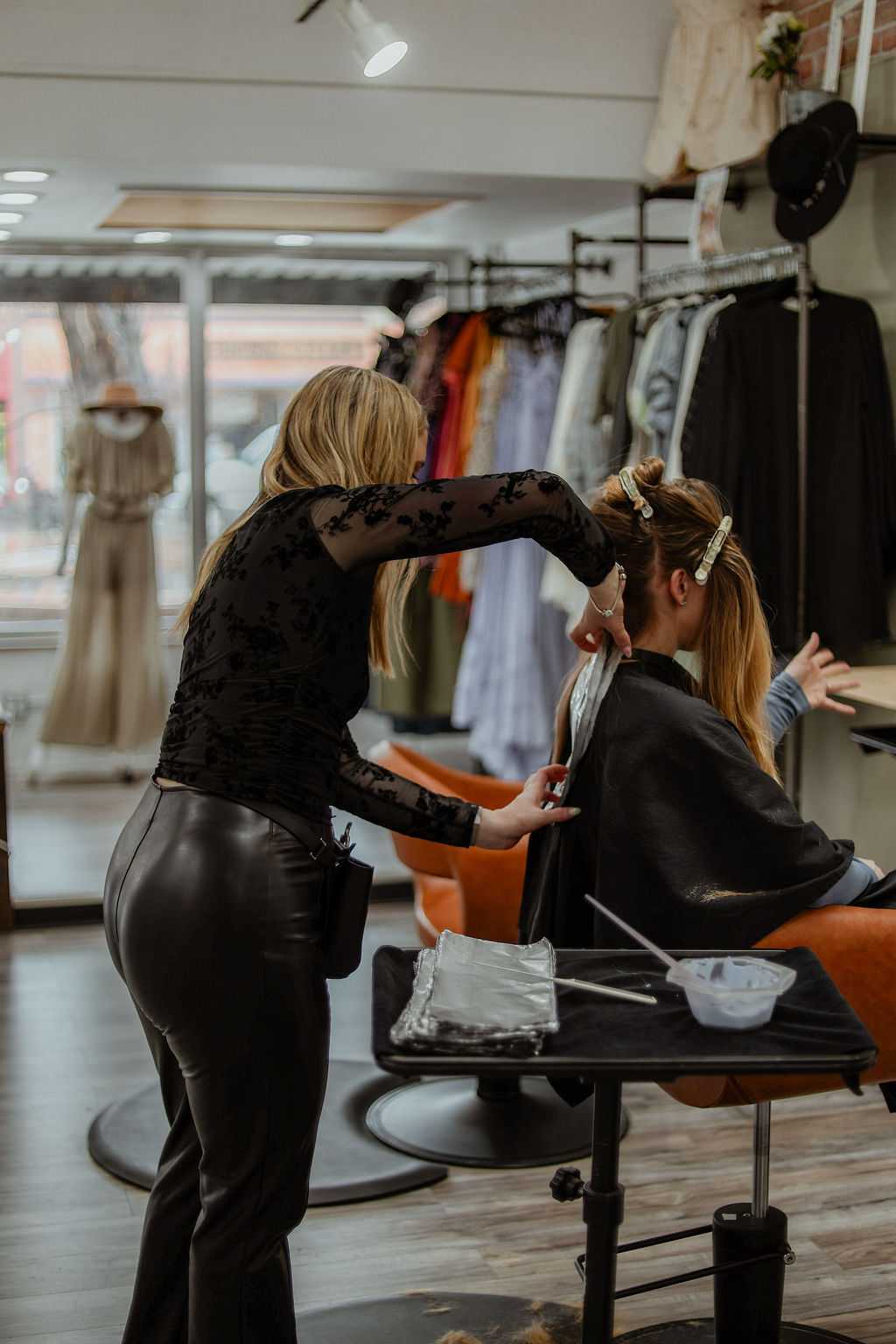 Hairdresser coloring a client's hair in a modern salon.
