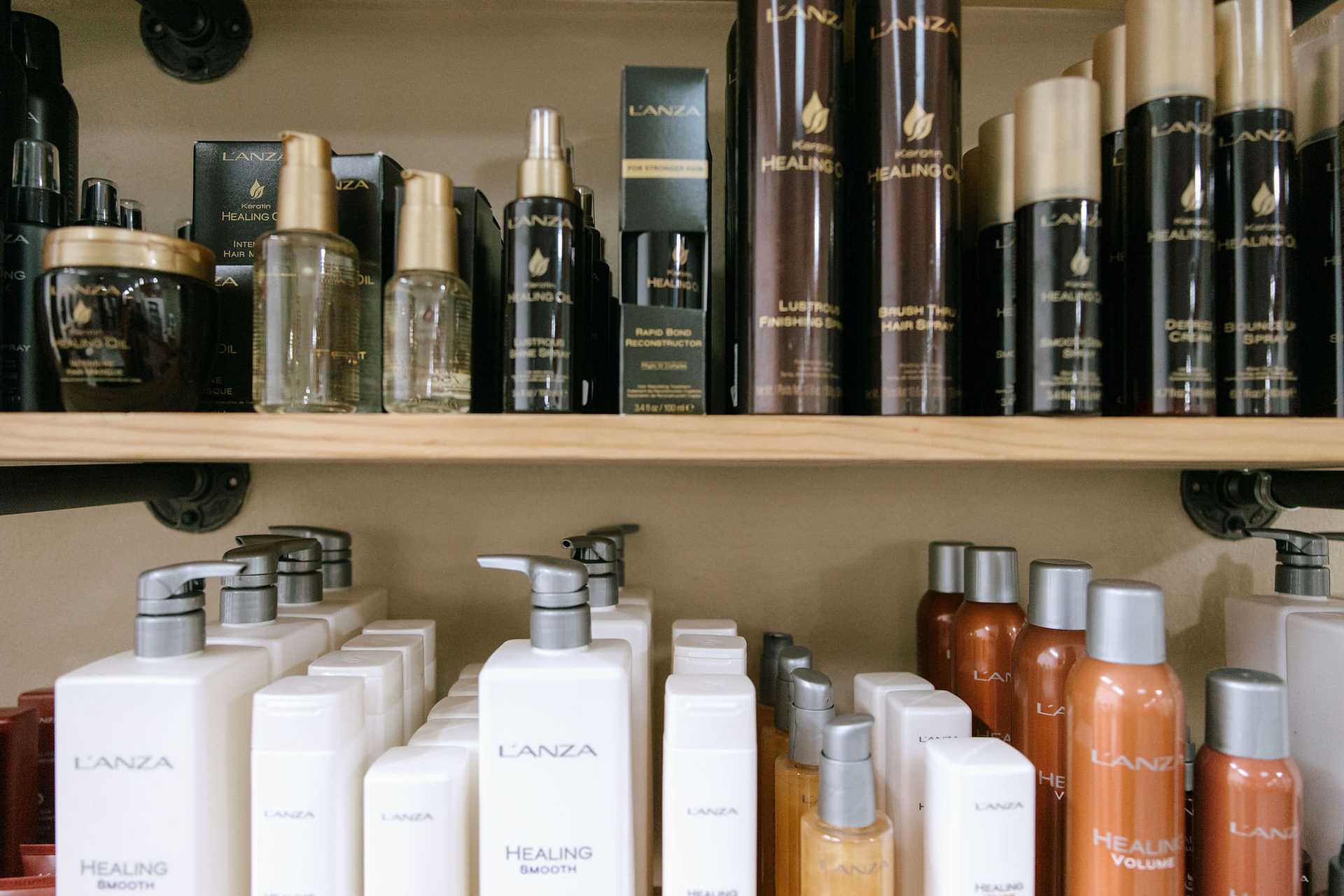 Shelf stocked with L'ANZA hair care products, including shampoos, conditioners, and sprays.