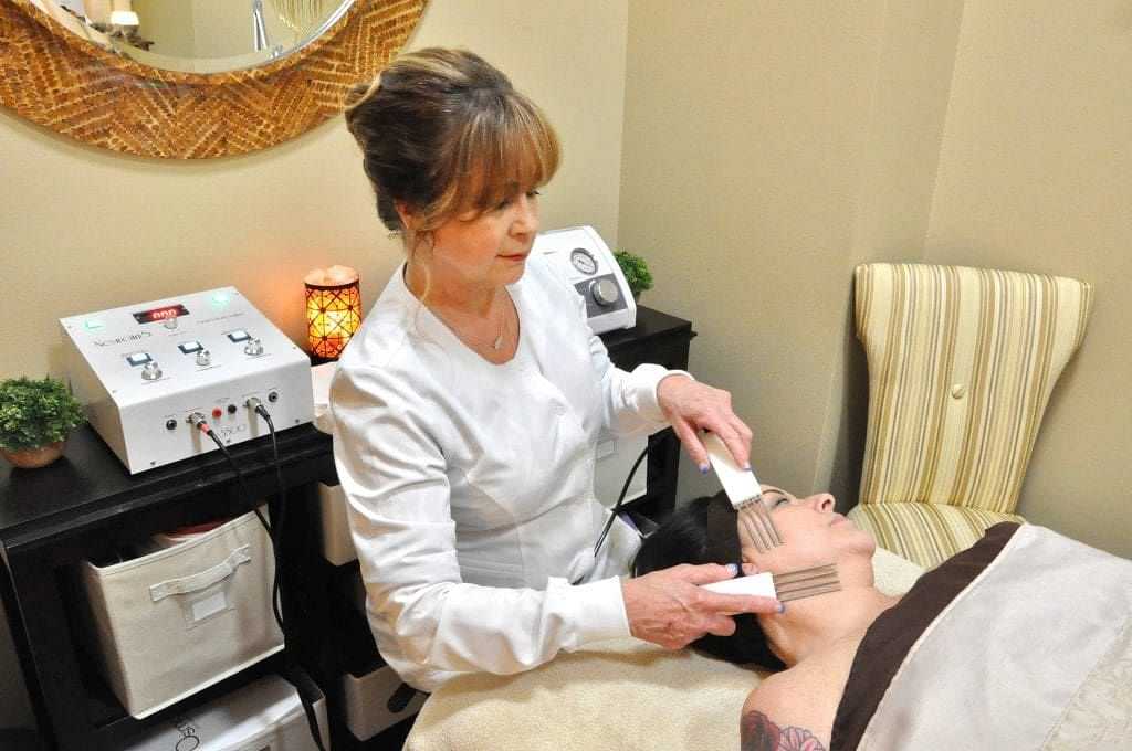 Esthetician performing a facial treatment on a client in a spa setting.