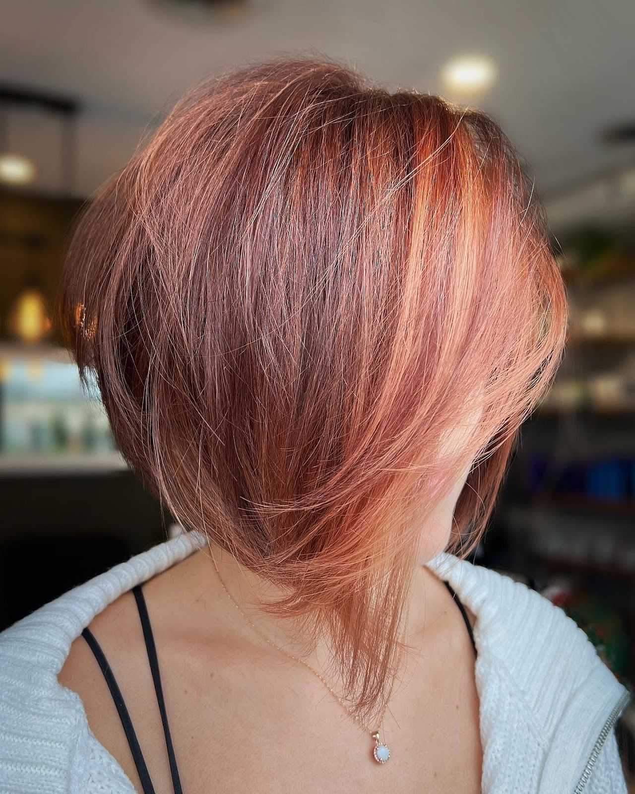 Pixie bob haircut with warm copper hues and subtle highlights.