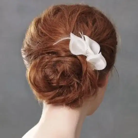Red hair in an elegant updo with a white flower accessory.