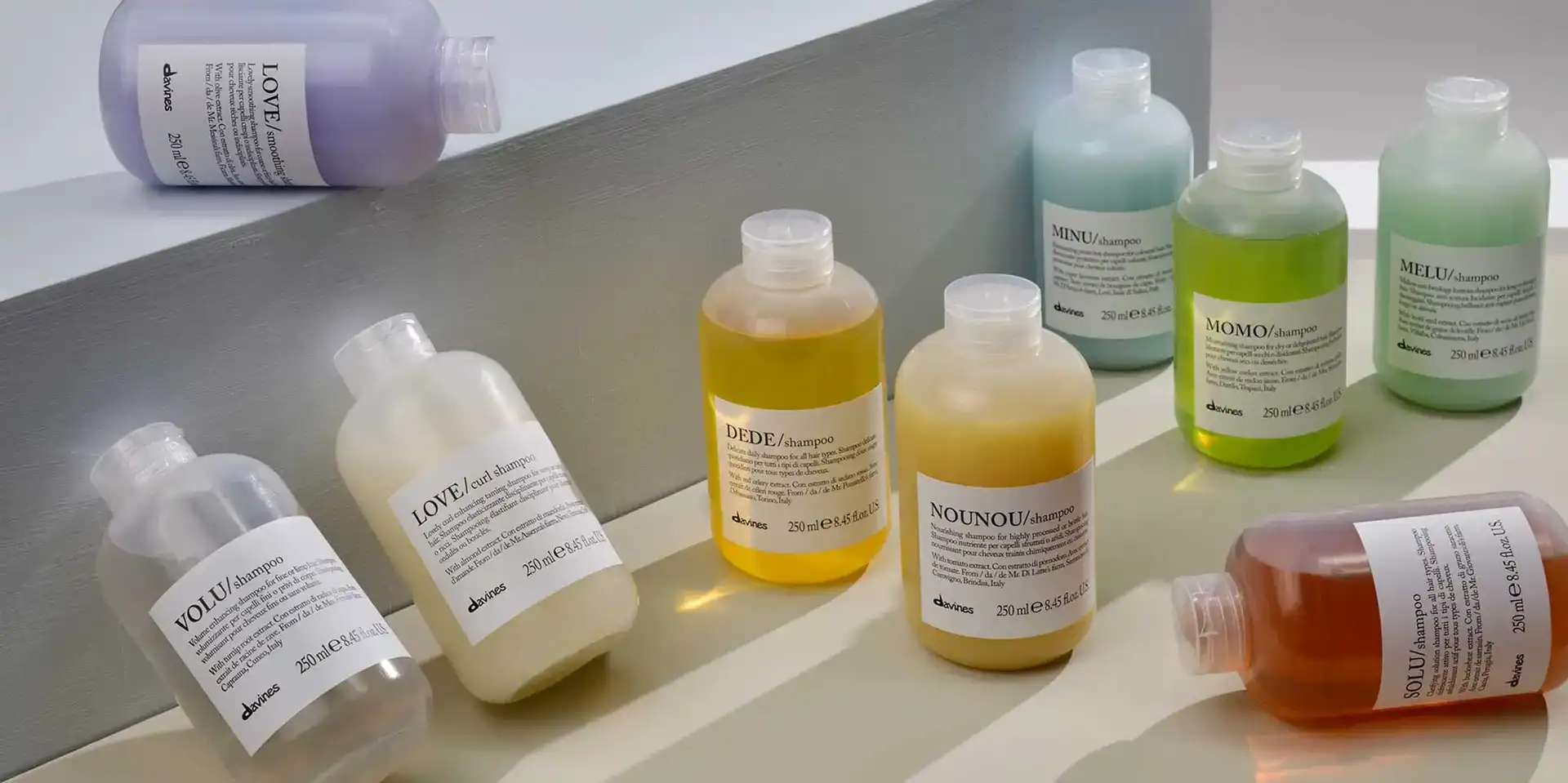 Bottles of colorful shampoo and conditioner displayed on a white surface.