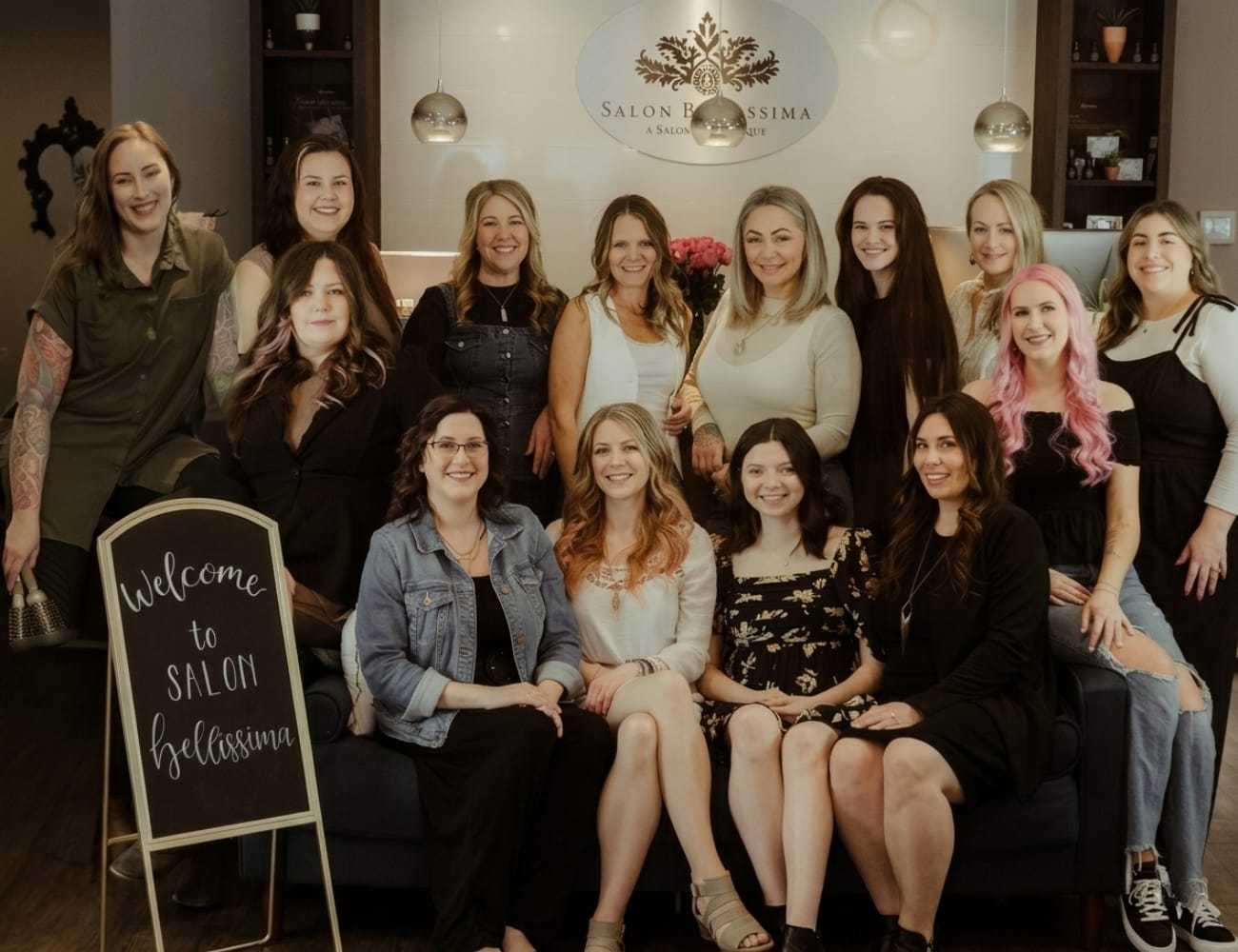 Group of salon staff posing together in a welcoming interior setting.