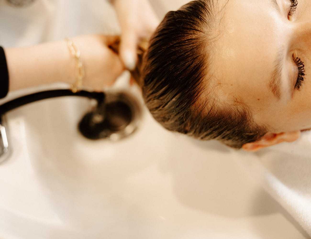 Person having their hair washed at a salon sink.