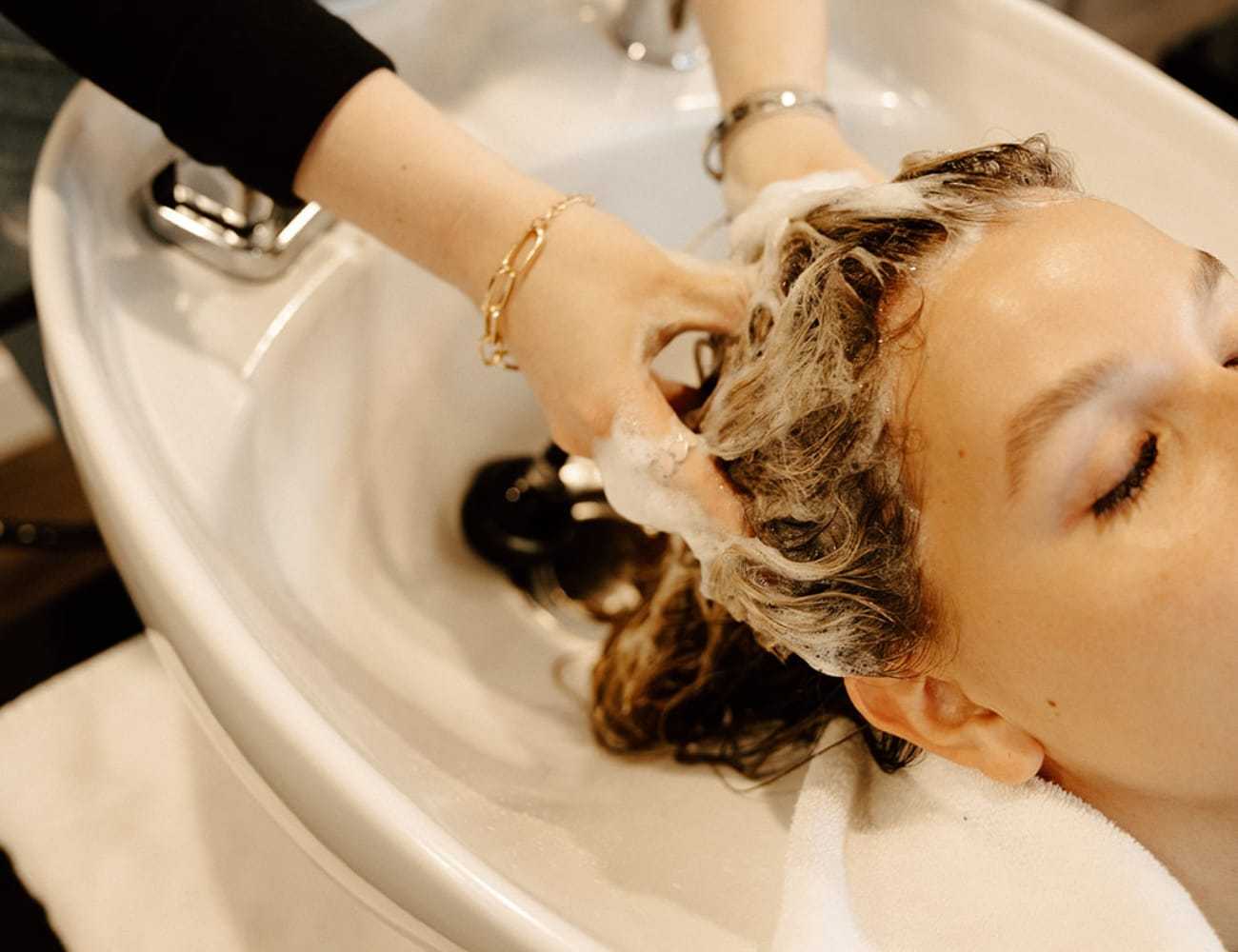Person receiving a hair wash at a salon sink.