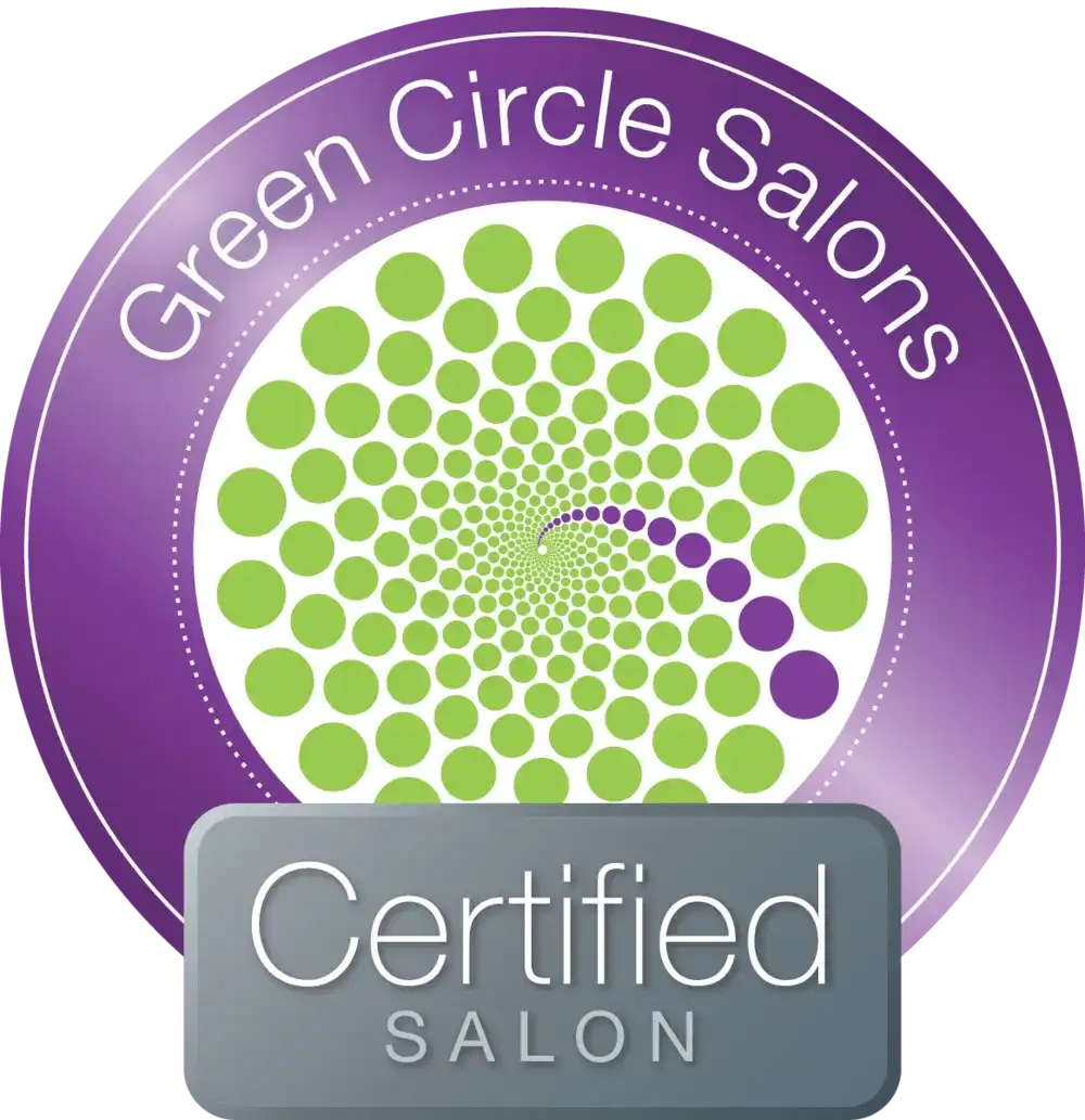 Purple and green "Green Circle Salons Certified Salon" emblem with circular pattern.