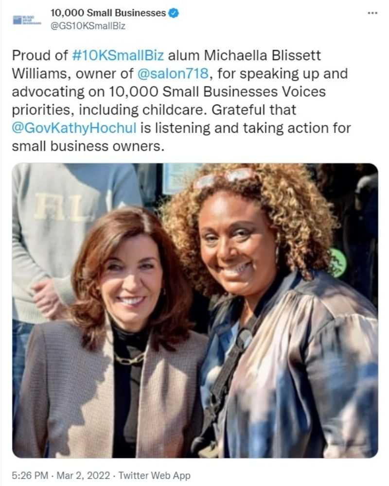 Two women smiling at a business event with supportive text overlay.