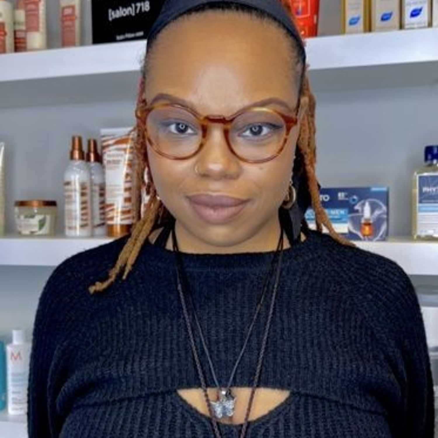 Portrait of Djenaba, a professional stylist at [salon] 718, showcasing their expertise and style.