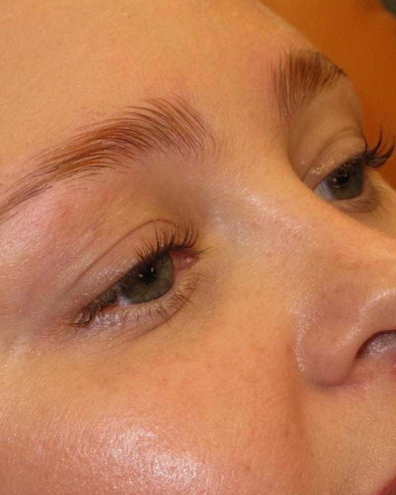 Close-up of a person's face focusing on eyes and eyebrows with natural makeup.