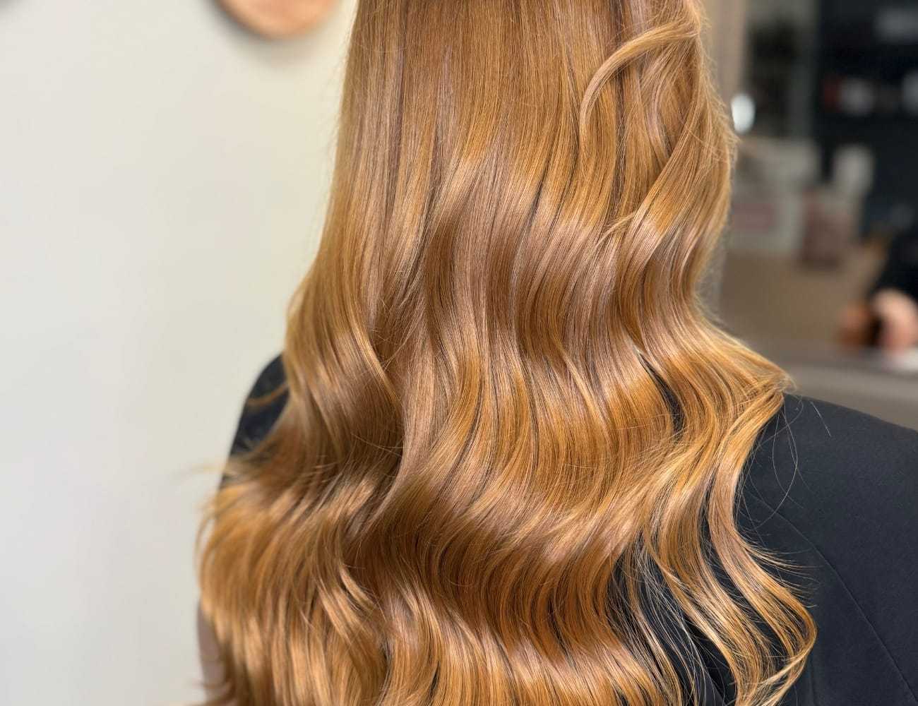 Wavy, long auburn hair from the back, styled smoothly.