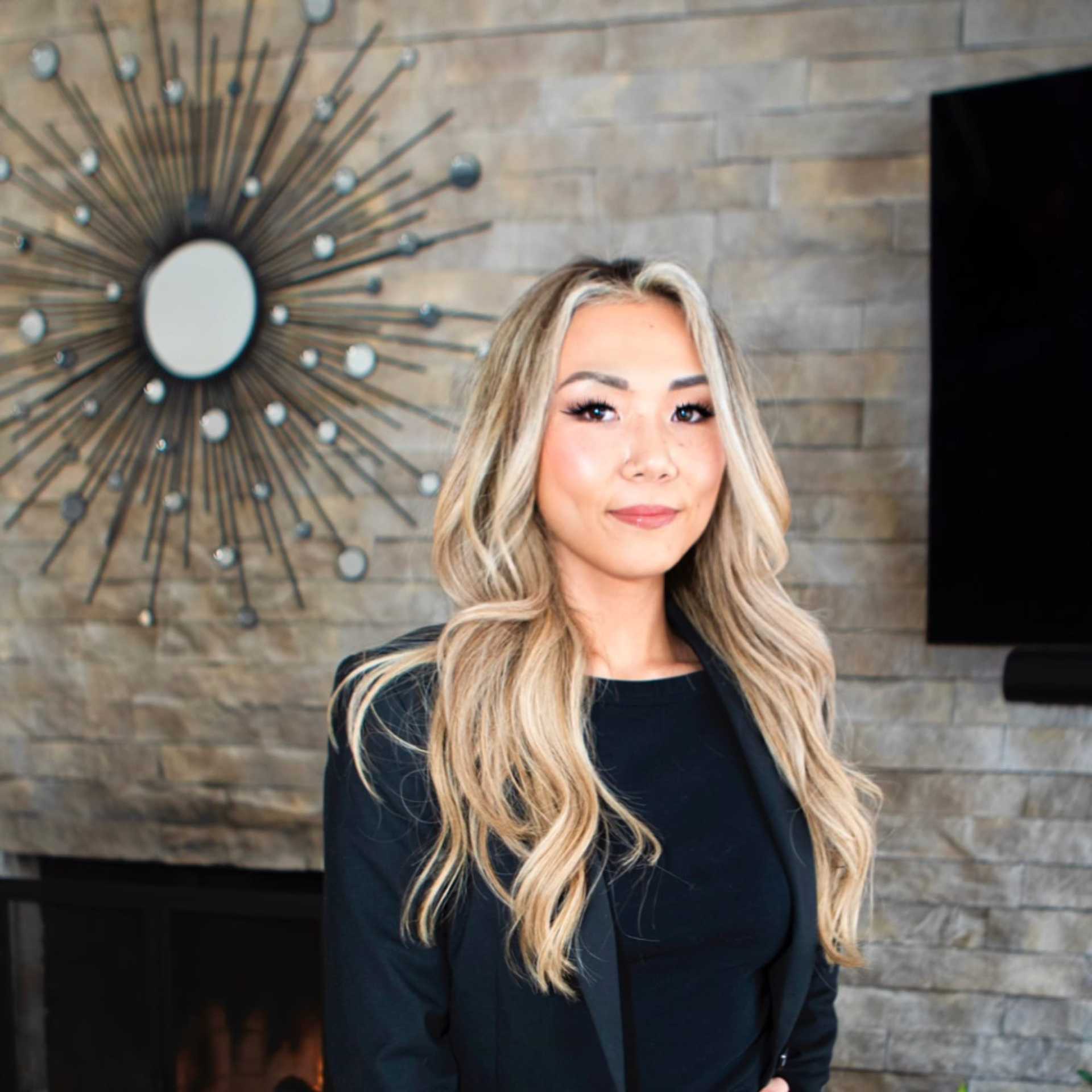 Portrait of Erina Adams, a professional stylist at Studio Raw Elite, showcasing their expertise and style.