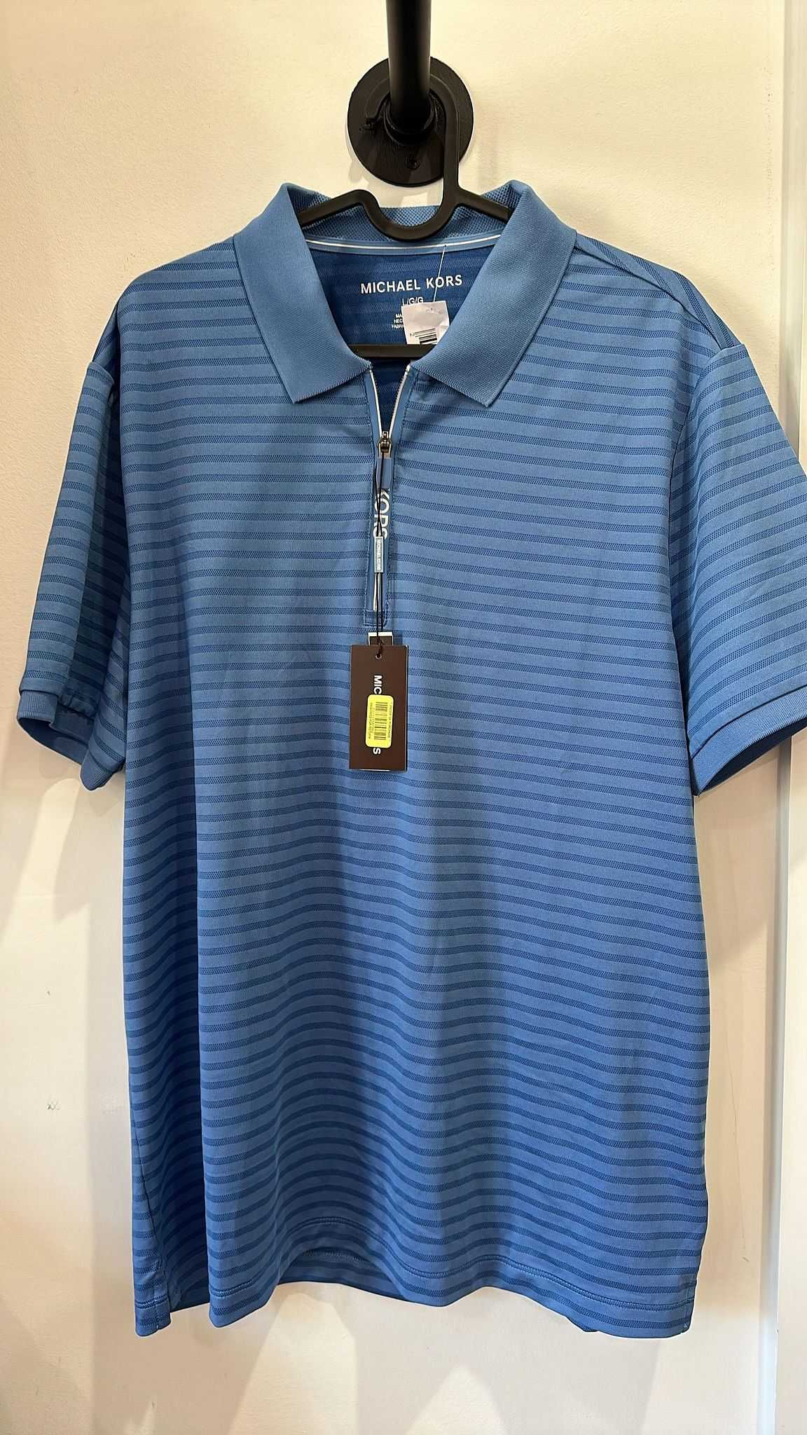 Blue striped polo shirt on a hanger with tag displaying "Michael Kors" brand.